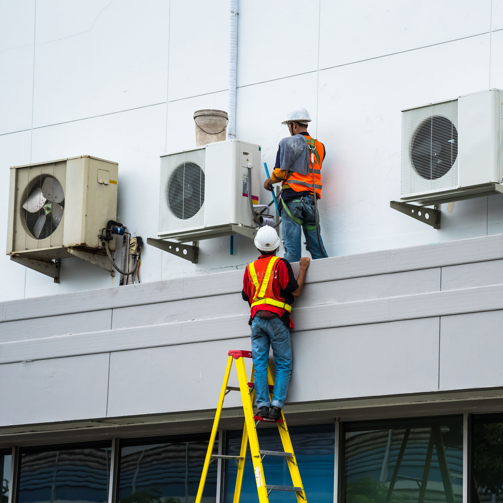 Technicians repairing an air conditioner