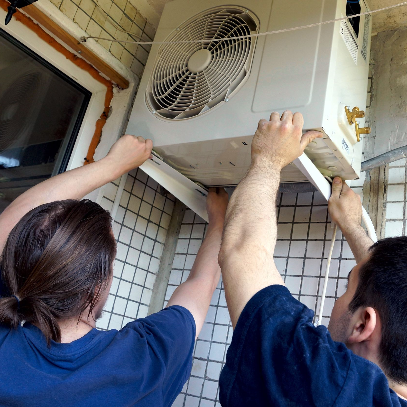 Technicians installing an air conditioner